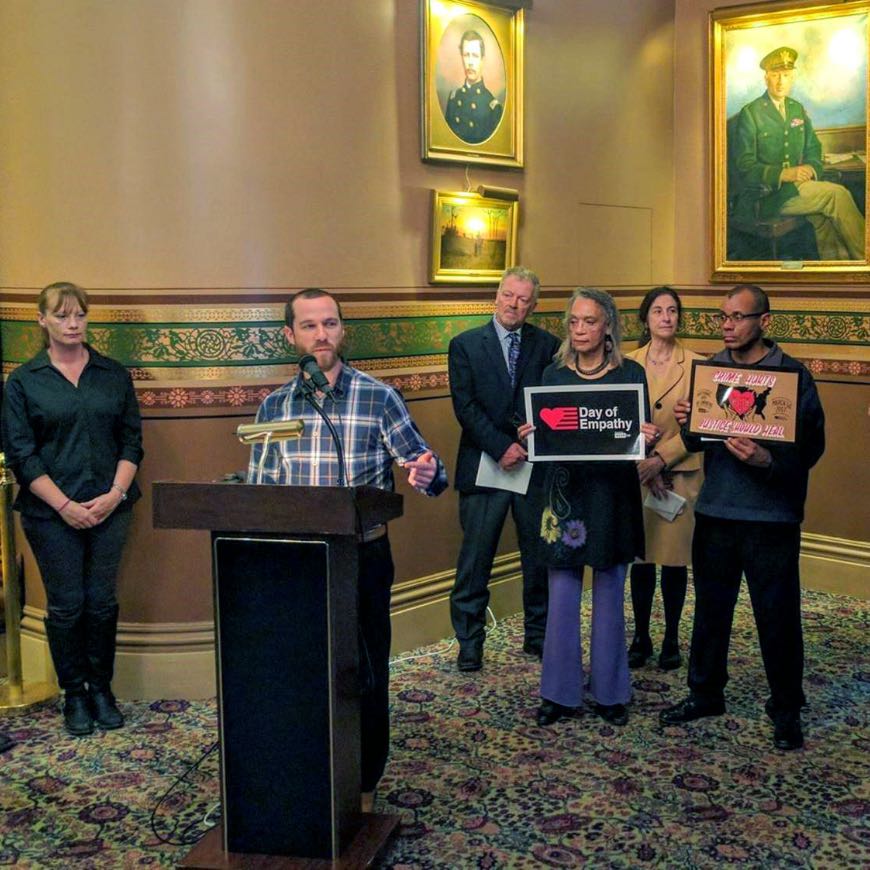 Vermonters for Criminal Justice Reform
Image of a group of people in the Vermont State House, holding signs that read "Day of Empathy" surrounding a gentleman speaker at a podium.